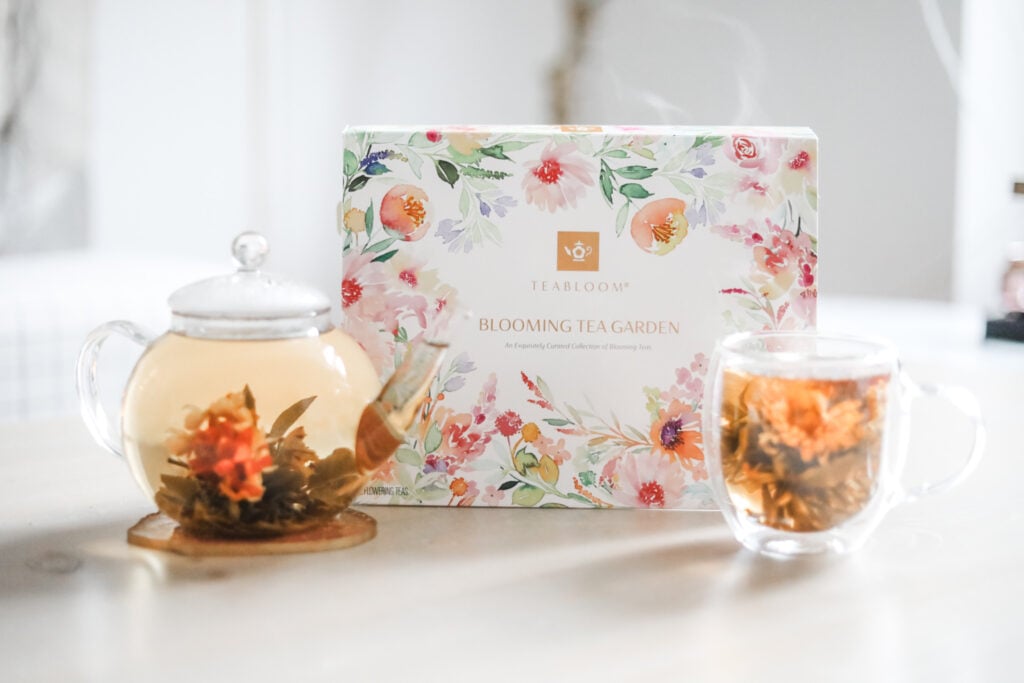 Blooming tea flower Blooming tea flowers in a large mug and glass teapot on a white table with a white and floral box of blooming flower teas.