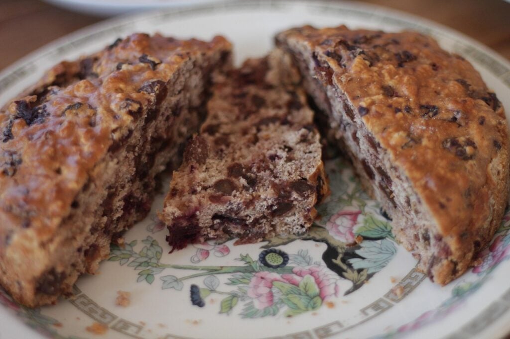  Fruit cake sliced in half on a flowery porcelain plate.