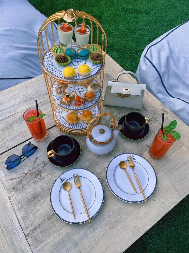 A linen picnic blanket with an elegant afternoon tea setup for a garden tea party.