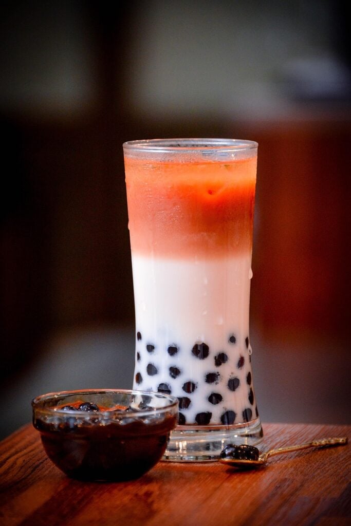 A tall cup of Boba tea with a ramekin of boba and a spoon featured as a tea from around the world.
