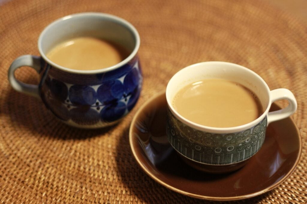 Two cups of Hong Kong milk tea in colorful teacups as an example of tea from around the world.