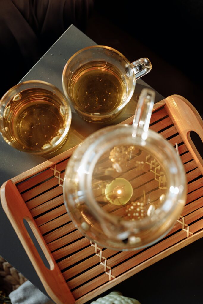Iced tea pitcher and two tea cups with steeped green tea