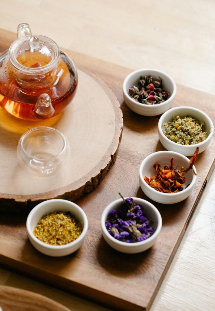 How to make herbal tea in a borosilicate glass teapot surrounded by small cups of dried herbs