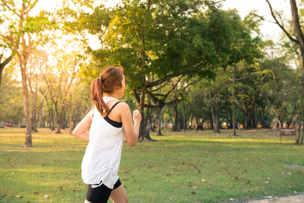 Woman running through a park with energizing health benefits of tea 
