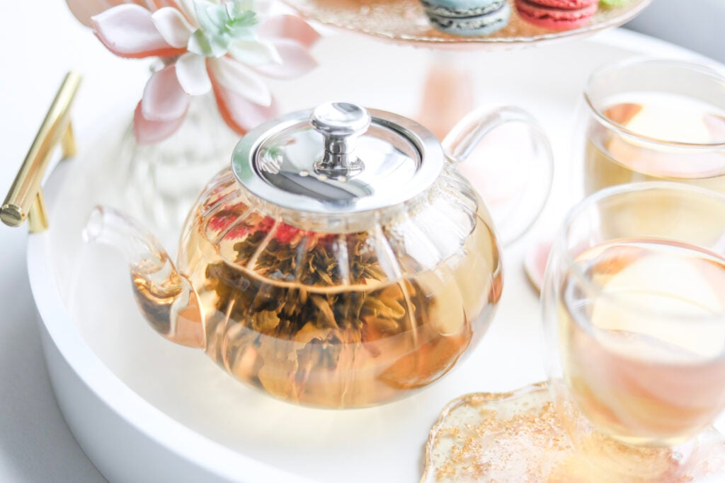 Sustainable tea in a teapot and glass teacups on a white tray