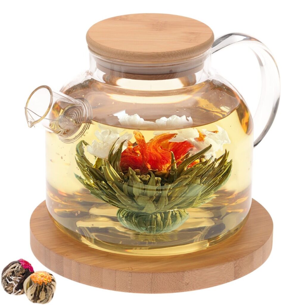 A glass and bamboo teapot and trivet with blooming flower teas.
