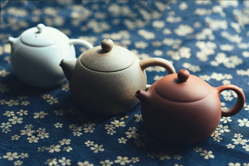 Tiny Chinese clay teapot sizes on blue cloth with white flowers