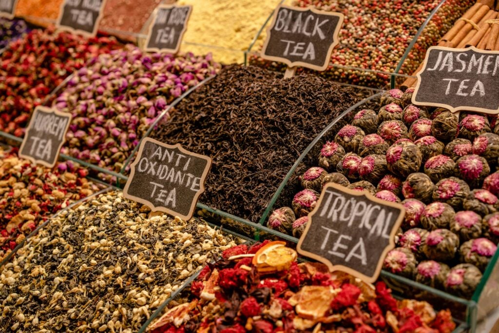 A large tea display stand with varieties of loose teas in large quantities.