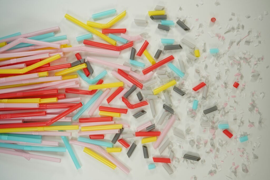 Colorful plastic straws cut into various size pieces as an example of microplastic waste.