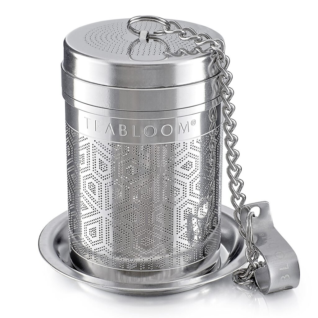 A stainless steel art deco-inspired tea infuser with a chain and hook for tea, stews, and sauces.
