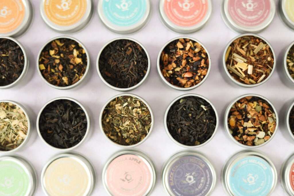 A closeup of small loose-leaf tea canisters as part of a collection for the best tea gift ideas for tea lovers.