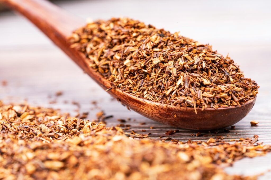 A wooden spoonful of dry rooibos tea leaves for an upset stomach.